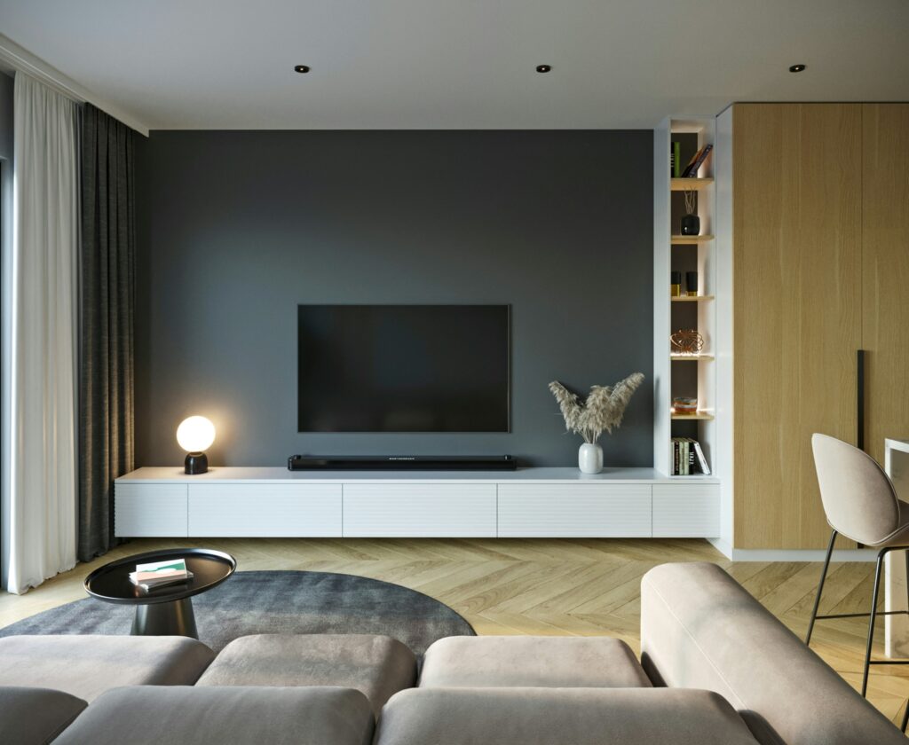 A modern living room with a wall-mounted TV and neutral furnishings